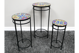 Set of 3 round side tables with black metal frames and colorful mosaic tile tops on gray carpet.
