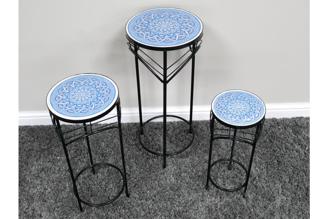 Set of three black metal side tables with round blue and white patterned tops, displayed on gray carpet.