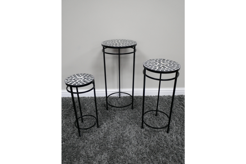 Set of 3 side tables with black metal frames and round mosaic tops in black and white, displayed on grey carpet.