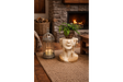Cream and gold distressed ceramic Head Side Table shaped like a face, angled with a plant on top in cozy room setting.