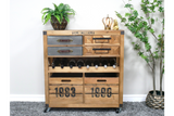 Wooden wine cabinet with metal and wood drawers, open bottle rack, and numbered crate compartments, shown in a room setting.