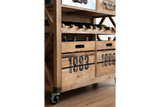 Light wood wine cabinet with storage crates marked "1983," horizontal bottle racks, and caster wheels, side angle view.