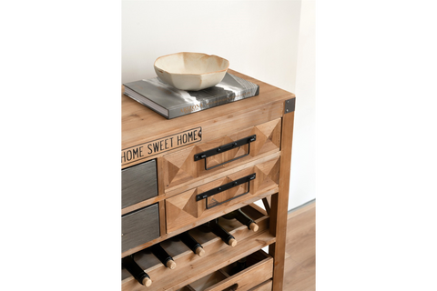 Wooden wine cabinet with drawers, black metal handles, wine bottle storage, and decorative bowl on top, angled view.