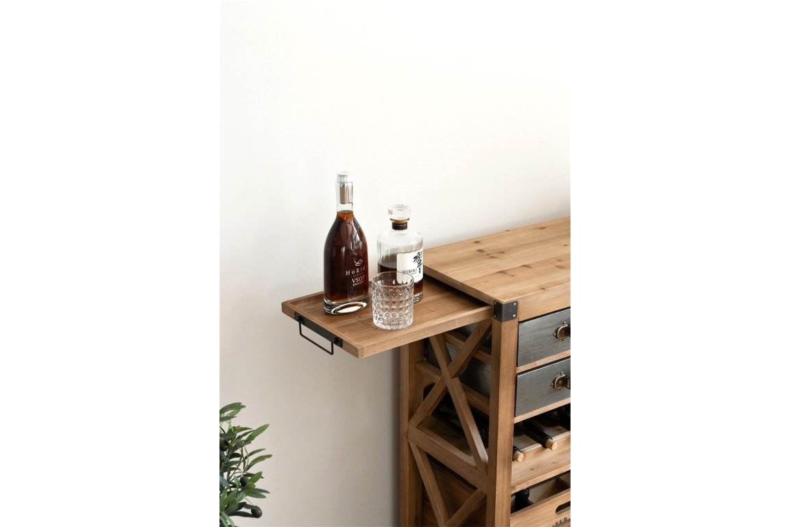 Wooden wine cabinet with pull-out tray holding two bottles and a glass, angled side view in a bright setting.
