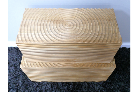 Set of two light wood rectangular storage boxes with carved circular and linear patterns, stacked on a dark rug.