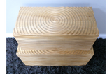 Set of two light wood rectangular storage boxes with carved circular and linear patterns, stacked on a dark rug.