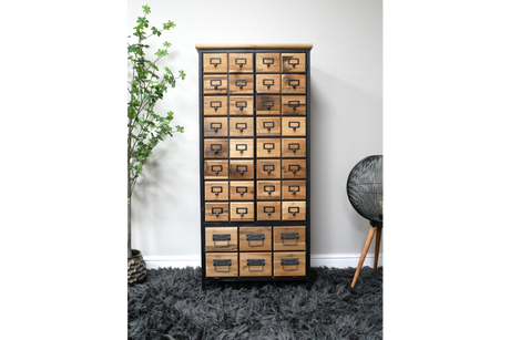 Wooden storage cabinet with multiple small drawers, black metal frame, shown front view on gray shaggy rug.