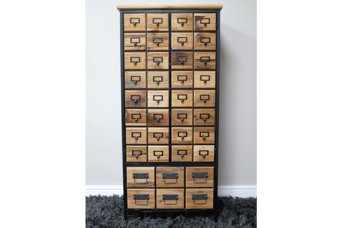 Tall wooden storage cabinet with multiple small and large drawers, black metal frame, front view on gray carpet.