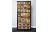 Tall wooden storage cabinet with multiple small and large drawers, black metal frame, front view on gray carpet.