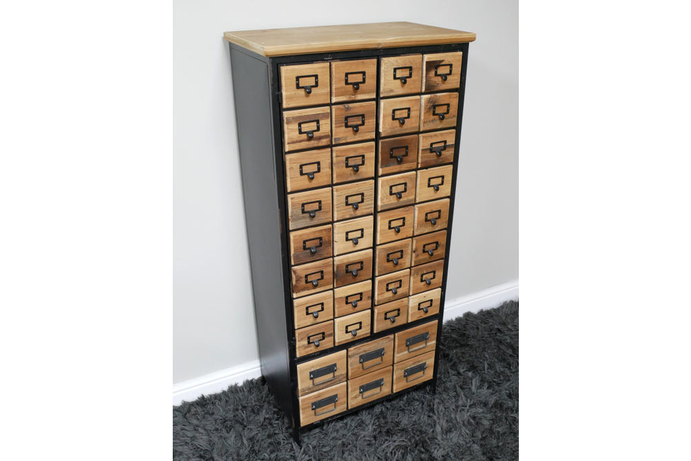 Tall storage cabinet with multiple small wooden drawers and black metal frame, angled view on gray carpet.