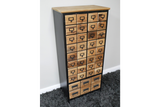 Tall storage cabinet with multiple small wooden drawers and black metal frame, angled view on gray carpet.