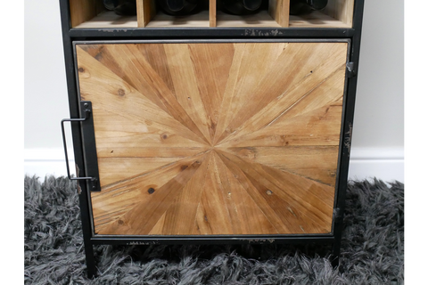 Wine cabinet with black metal frame, light wood geometric patterned door, standing on grey shaggy rug, front view.