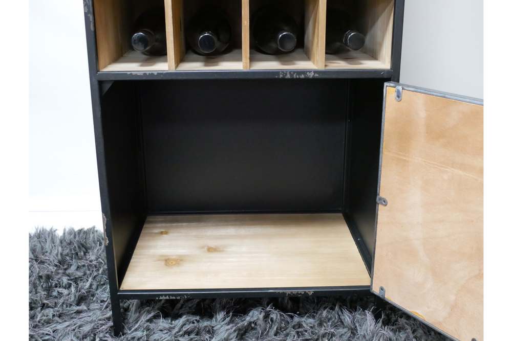 Black metal and light wood wine cabinet with four wine slots, open door, shown from front on dark rug.