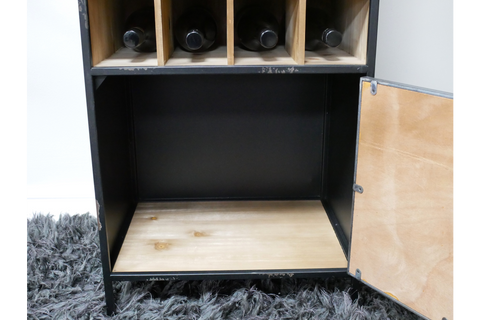 Black metal and light wood wine cabinet with four wine slots, open door, shown from front on dark rug.