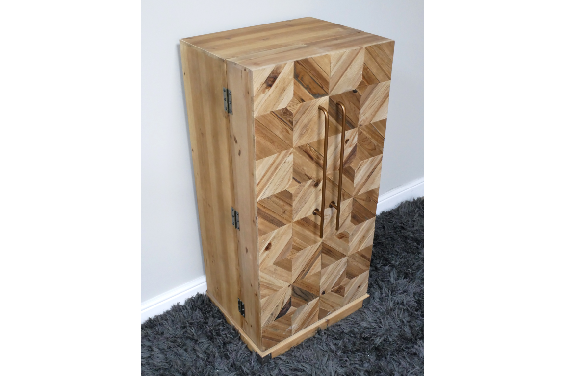 Wooden wine cabinet with geometric patterned front, bronze handles, viewed from a side angle on grey carpet.