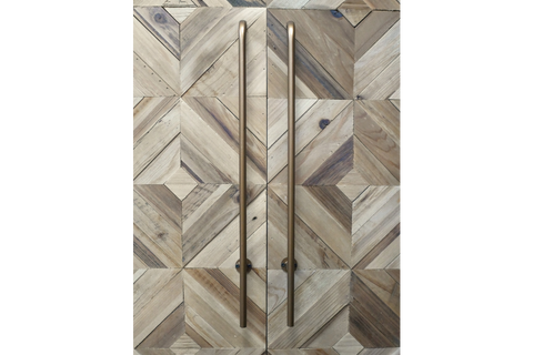 Wine cabinet with geometric patterned wood doors in natural tones and tall bronze handles, front view.