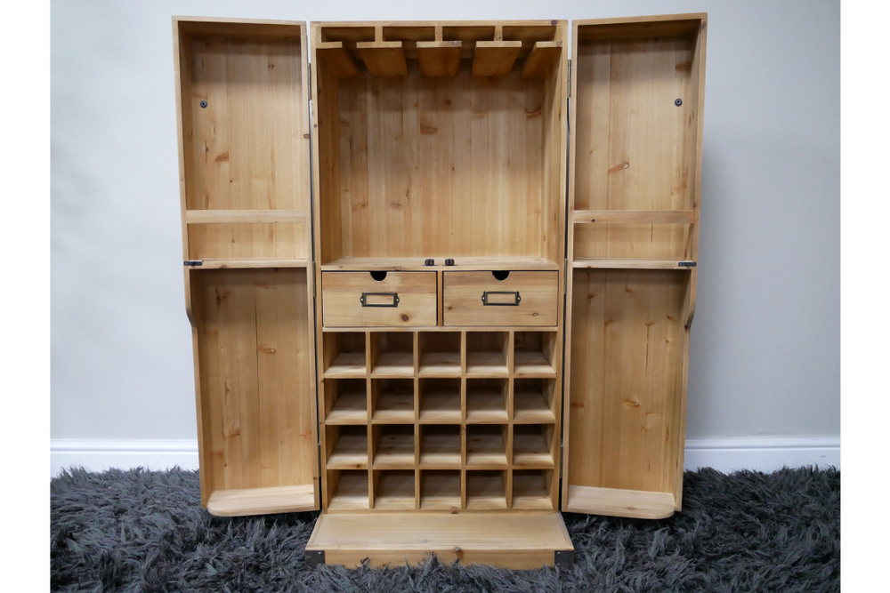 Light wood wine cabinet with open double doors, row of bottle slots, two drawers, and hanging rack, front view.