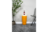 Cylindrical mustard yellow Lager Side Table with cream top, displayed on grey carpet between plant and black wire chair.