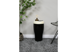 Black and white ceramic stout side table with lamp and smartphone on top, shown in a carpeted room corner from front angle.