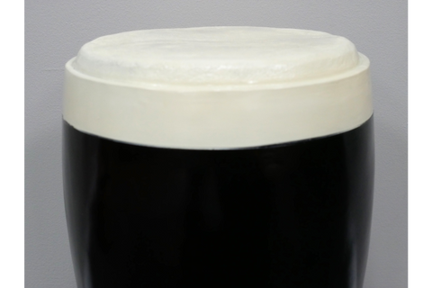 Round stout side table with black glossy base and off-white textured top, shown from a front angle on a gray background.