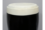 Round stout side table with black glossy base and off-white textured top, shown from a front angle on a gray background.