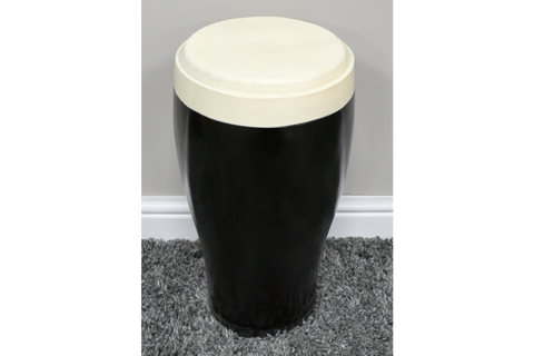 Black and white ceramic stout side table with rounded top, cylindrical shape, shown on gray carpet against beige wall.