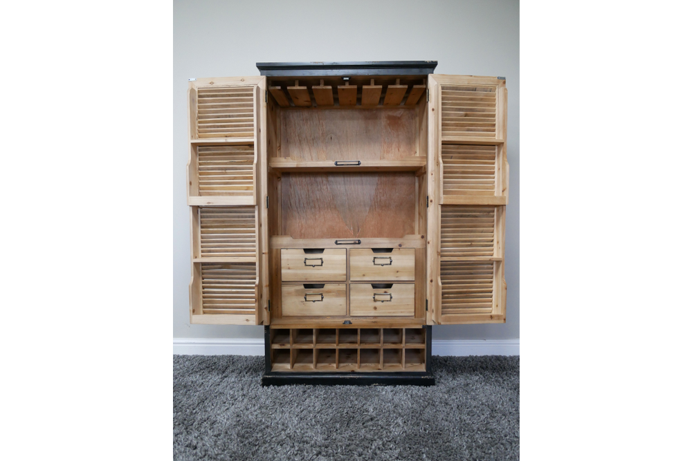 Wooden shutter bar cabinet with natural and black finish, open front showing shelves, drawers, and bottle slots, front view.