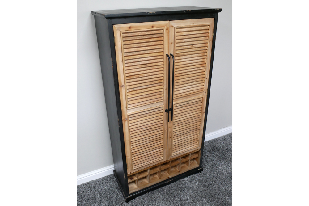 Tall shutter bar cabinet with natural wood louvered doors, black frame, metal handles, and built-in wine rack, angled view.