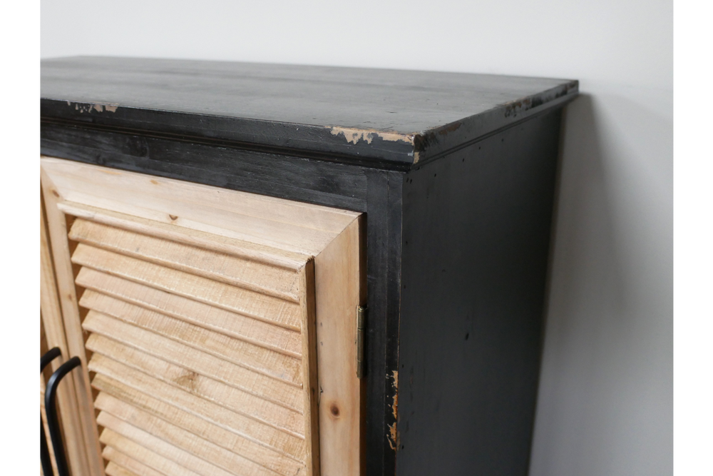 Shutter bar cabinet with distressed black wood frame and natural unfinished wooden louvered door, side angle view.