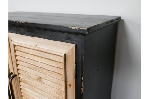 Shutter bar cabinet with distressed black wood frame and natural unfinished wooden louvered door, side angle view.