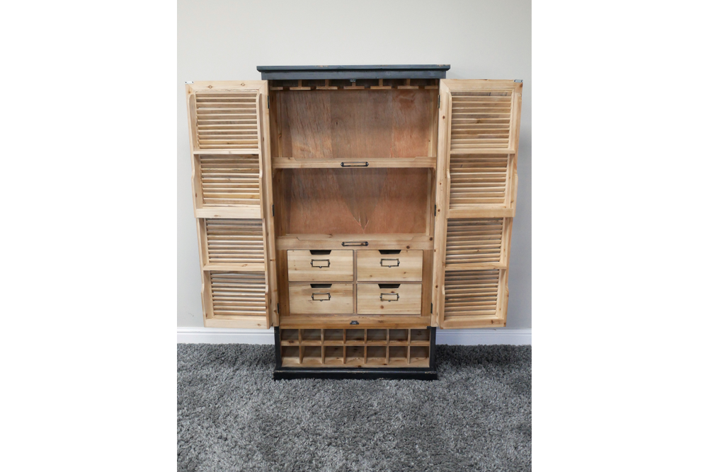 Wooden shutter bar cabinet with louvered doors open, four small drawers, wine rack base, natural and black finish, front view