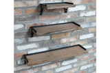 Set of 3 rectangular wooden wall shelves with black metal brackets, mounted on a textured brick wall, side angled view.