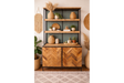 Wood and metal bar cabinet with two doors and two open shelves, styled with plants and woven decor, front view.