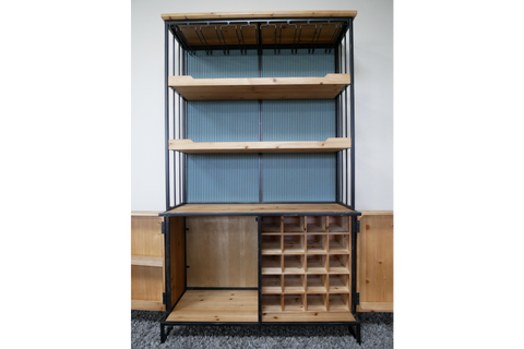 Tall bar cabinet with black metal frame, natural wood shelves, wine bottle slots, and ribbed blue back panel, front view.