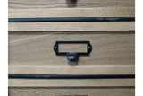 Close-up of light brown wooden industrial drawer cabinet with black metal handle and label holder.