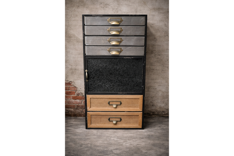 Tall industrial drawer cabinet with mixed metal and wood drawers, black frame, brass handles, front view against textured