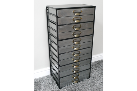 Tall industrial drawer cabinet with ten gray metal drawers and brass handles, side angled view on carpeted floor.