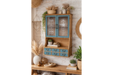 Wooden Parisienne wall unit with blue cabinet doors and drawers, glass panels with white text, staged with plants and decor.