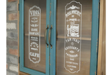 Wooden wall unit with blue distressed framed glass doors showing white vintage French bakery signs.