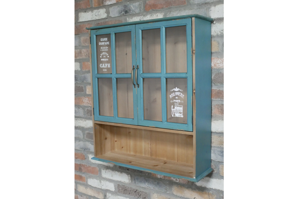 Blue wooden Parisienne Wall Unit with glass paneled doors and open lower shelf, mounted on brick wall.