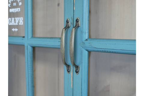 Close-up of blue painted wooden wall unit doors with metal handles and glass panels.