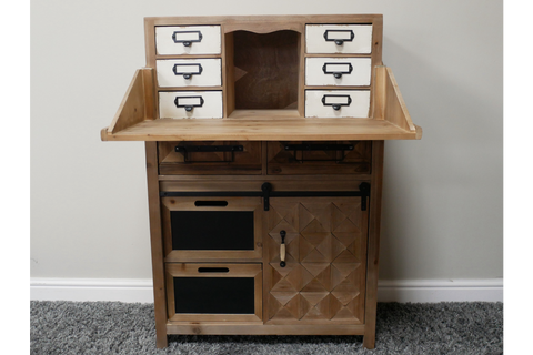 Rustic wooden cabinet with six white drawers on top, two chalkboard panels, and a geometric wooden door below, front view.
