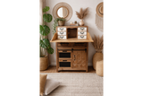 Rustic wooden cabinet with small white drawers, black metal handles, and a folding top panel in a boho room setting.