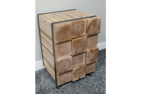 Chunky bedside cabinet made of light natural wood blocks with visible grain, metal frame, and caster wheels, shown at an