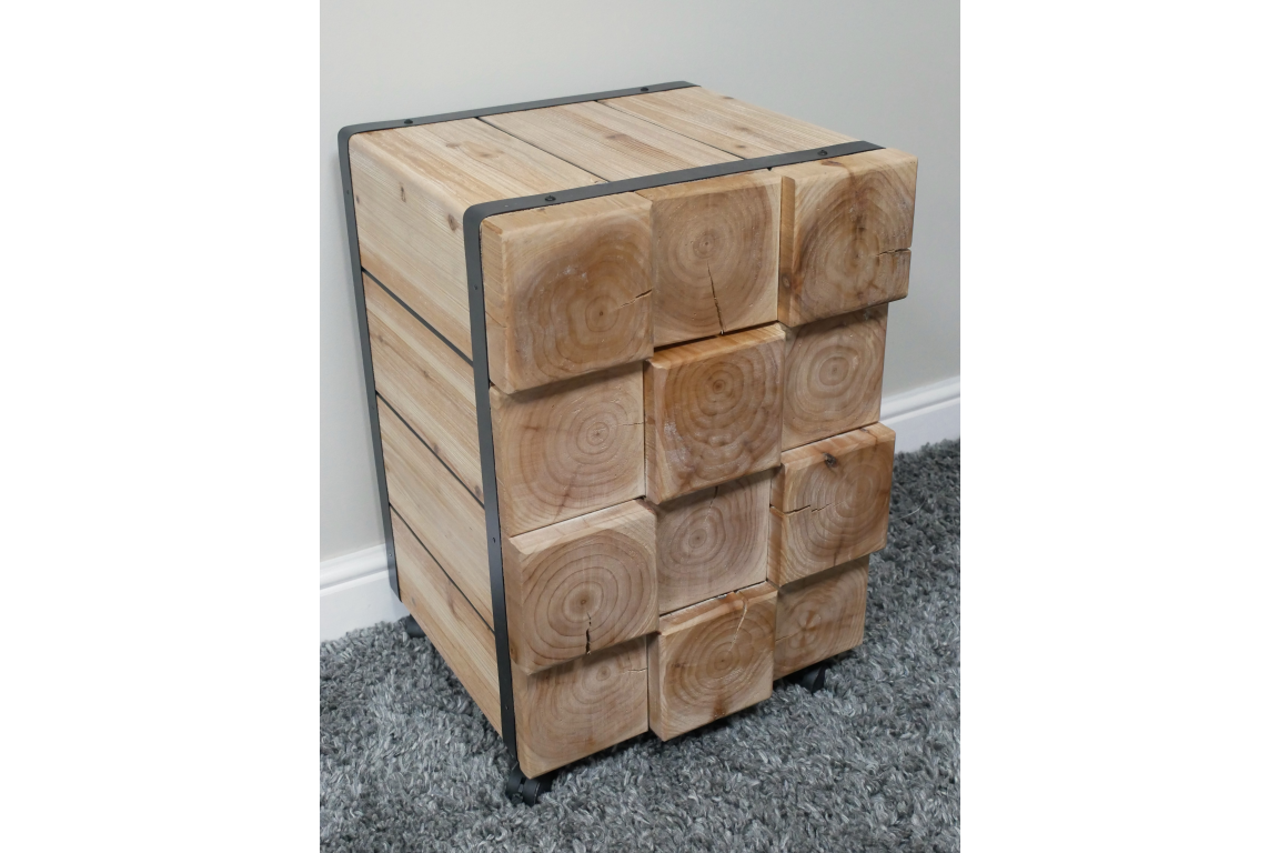 Chunky bedside cabinet made of light natural wood blocks with visible grain, metal frame, and caster wheels, shown at an