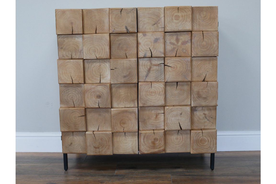Chunky wooden cabinet with natural finish, square log block design front, standing on black metal legs, front view.