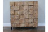 Chunky wooden cabinet with natural finish, square log block design front, standing on black metal legs, front view.