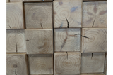 Close-up view of chunky cabinet showing light natural wood blocks with visible grain patterns and cracks.
