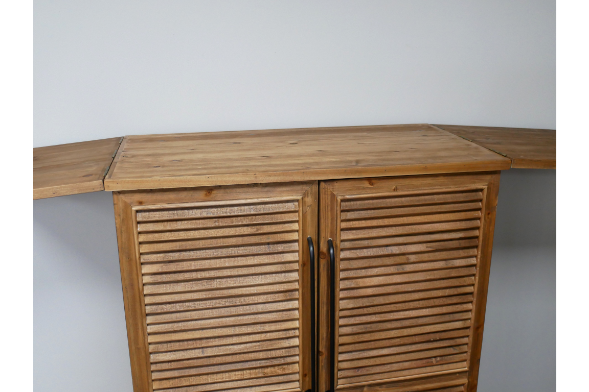 Wooden shutter bar cabinet with fold-out wing doors, black handles, photographed from front angle against white wall.
