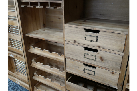 Light brown wooden shutter bar cabinet with wine rack and three drawers, shown from a front angle.